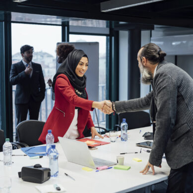 Business partners shaking hands at meeting in office