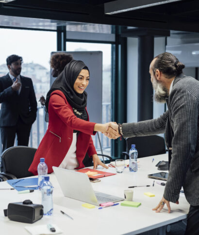 Business partners shaking hands at meeting in office