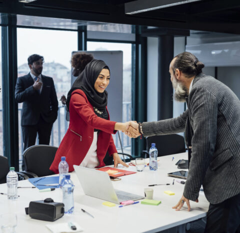 Business partners shaking hands at meeting in office