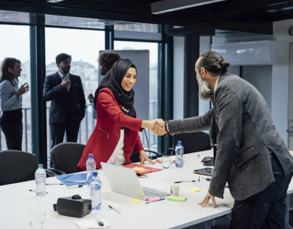 Business partners shaking hands at meeting in office