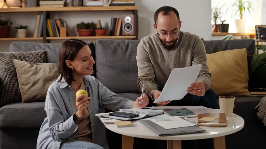 Expatriés à Dubaï construisant leur budget mensuel avec factures et tablette